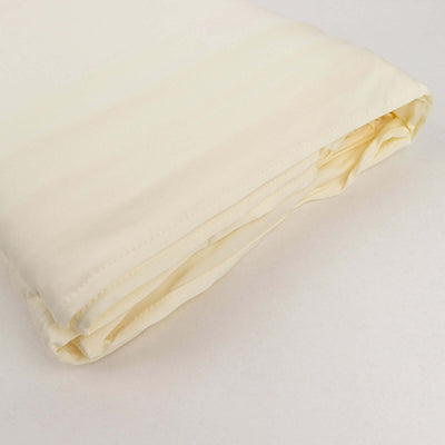 Cream-colored folded bed sheet on a plain background