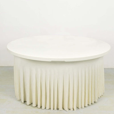 Round white table with a pleated skirt, studio shot.