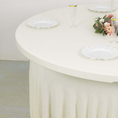 Round table set with white plates and floral centerpiece.