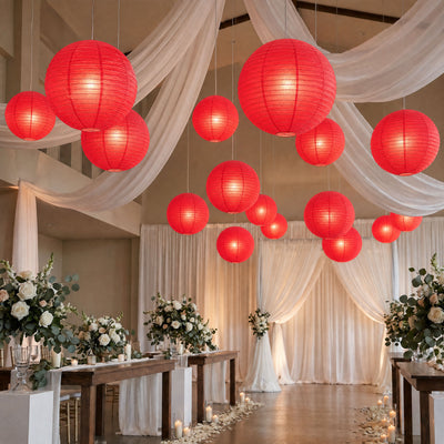 Red lantern wedding reception with floral tables and draped white decor