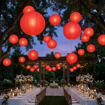 Outdoor wedding reception with red lanterns and elegant floral tablescape