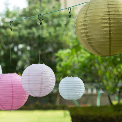 Colorful paper lanterns hanging outdoors in a garden setting.