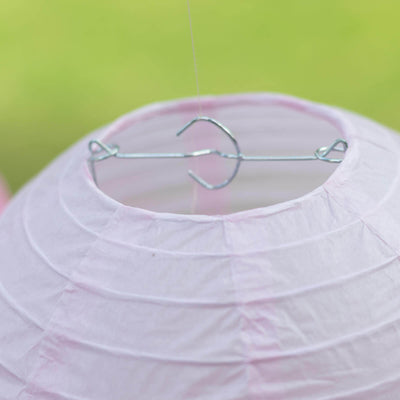 Pink paper lantern with metal hook for hanging.