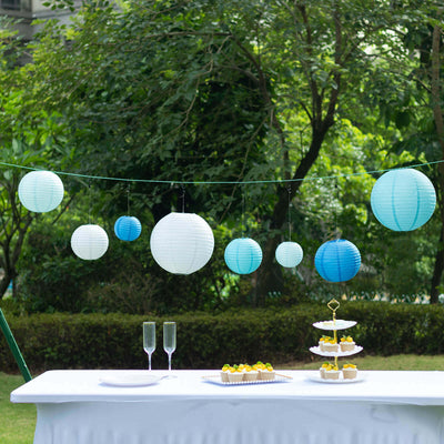 Colorful hanging paper lanterns at an outdoor celebration table.