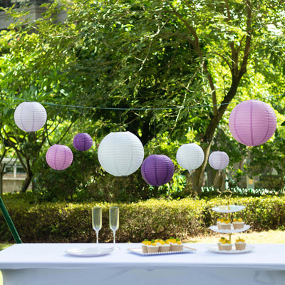 Colorful paper lanterns hanging above a table set for a celebration.