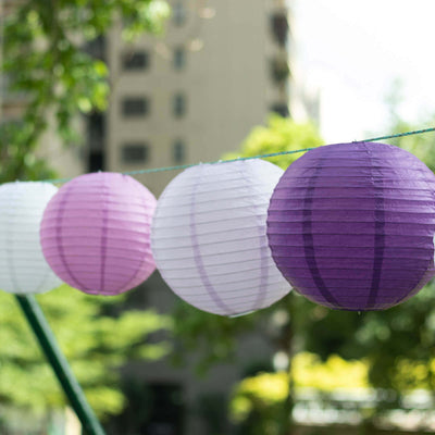 Colorful paper lanterns hanging outdoors in a garden setting.