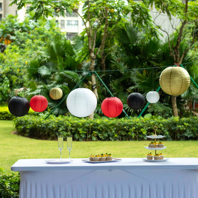 Colorful hanging lanterns at an outdoor party with a table setting.