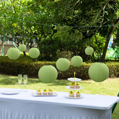 Green paper lanterns hanging at an outdoor event with a dessert display.