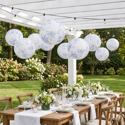 Elegant outdoor garden dining table with floral lanterns and white table settings