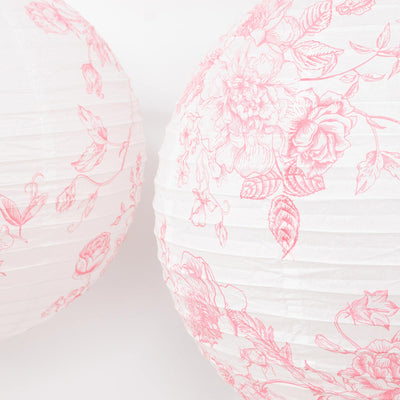 Pink floral paper lanterns with delicate botanical pattern on white background
