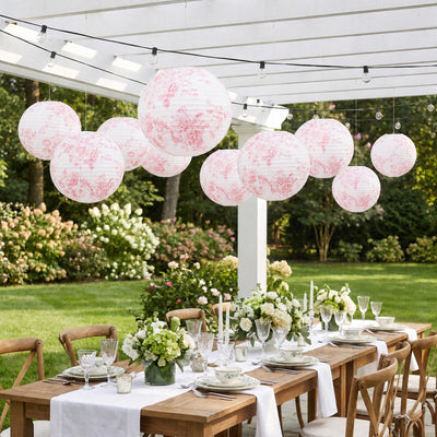 Elegant outdoor garden party table with floral lanterns and white rose centerpieces
