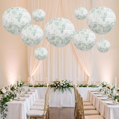 Elegant wedding reception with floral lanterns, white tables, and gold chairs