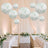 Elegant wedding reception with floral lanterns, white tables, and gold chairs