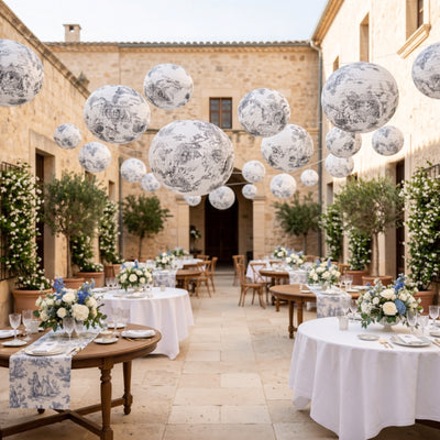 Elegant outdoor wedding setup with floral centerpieces and decorative hanging lanterns.