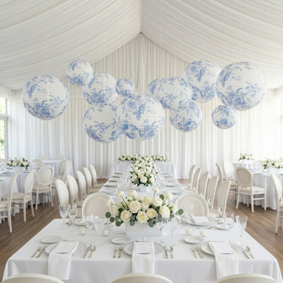 Blue and white floral paper lanterns hanging over an elegant dining setup.