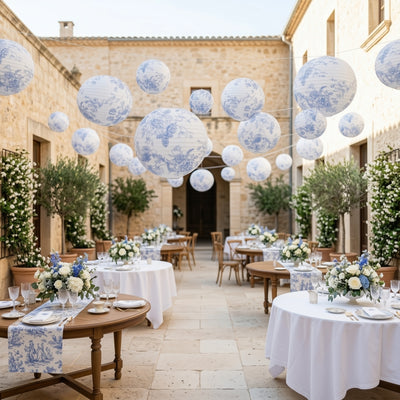 Elegant outdoor dining setup with floral decor and blue patterned lanterns.
