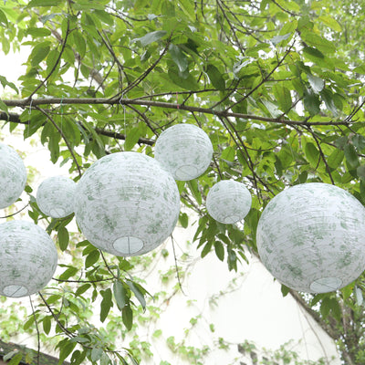 Decorative paper lanterns hanging among green leaves.