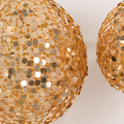 Gold sequined decorative balls on a white background.
