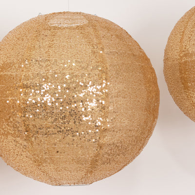 Gold sequin lanterns hanging against a neutral background.