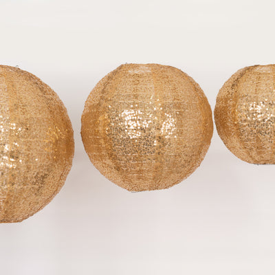 Gold decorative lanterns in a row against a plain background