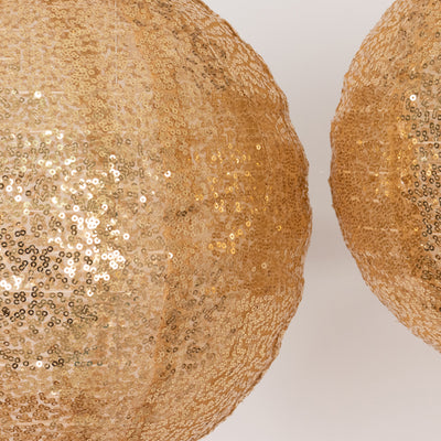 Gold sequin decorative lanterns hanging in a studio setting.