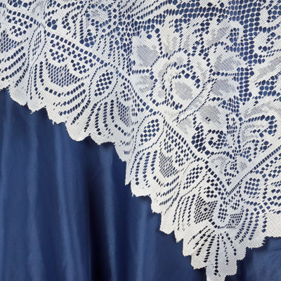 White lace tablecloth edge on blue satin background.