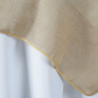 Burlap table runner with gold trim on a white tablecloth
