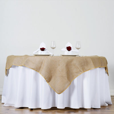 Elegant table setting with burlap tablecloth and rose-decorated napkins.