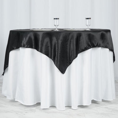 Elegant black satin tablecloth draped over a white table.