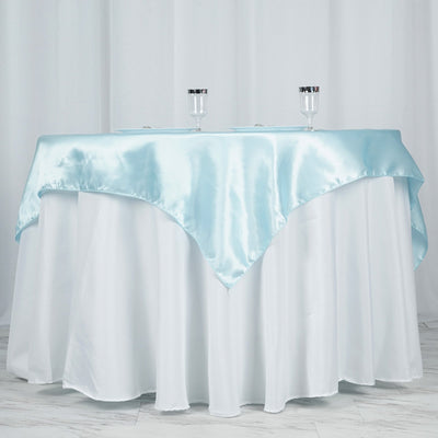 Elegant light blue satin table overlay on a white tablecloth.