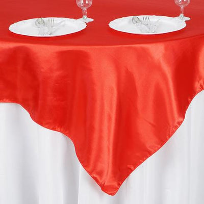 Red satin tablecloth draped elegantly over a white table.