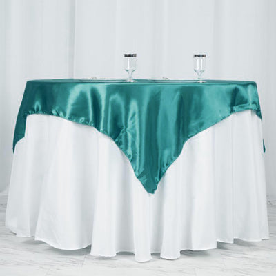 Teal satin tablecloth draped elegantly over a white table.