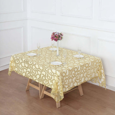 Yellow lace tablecloth on a dining table with floral centerpiece and dinnerware.