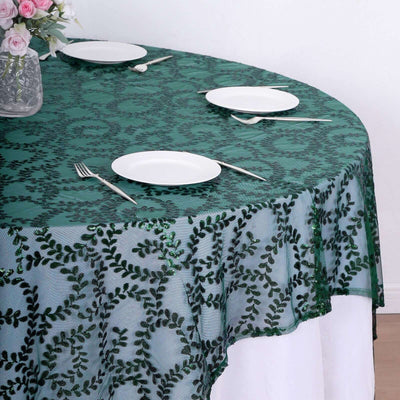 Green sequin tablecloth with leaf pattern draped over a round table.