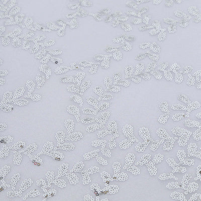 Silver leaf embroidery design on white fabric.