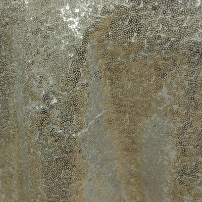 Shimmering silver sequin fabric texture close-up.
