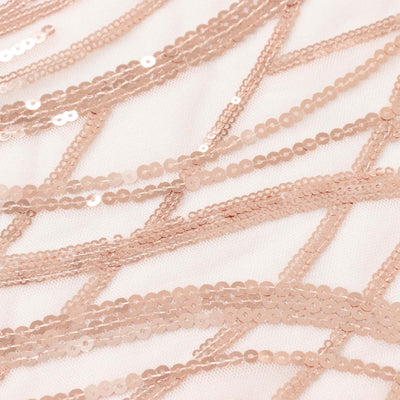 Rose gold sequin fabric with intricate patterns and textures.