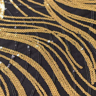 Gold sequin pattern on black fabric, showcasing wavy design and texture.