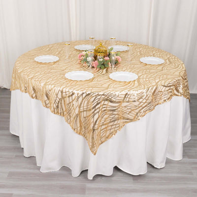 Elegant round table with gold patterned tablecloth and white plates arranged neatly.