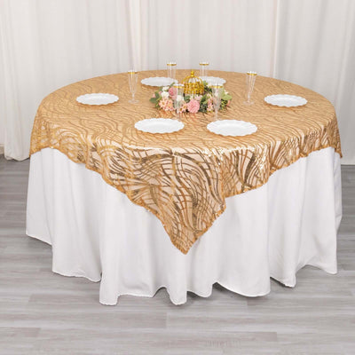 Round table decorated with a gold lace tablecloth and floral centerpiece.