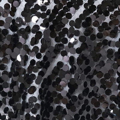 Black sequin fabric texture with shiny circular embellishments.