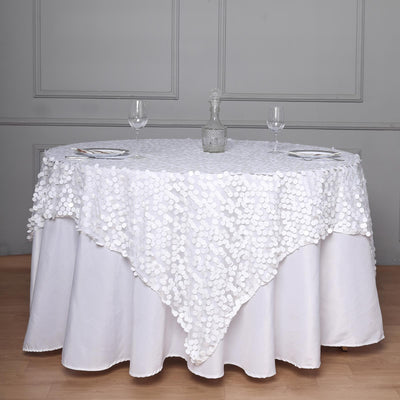 White table with decorative sequin tablecloth and glassware set.