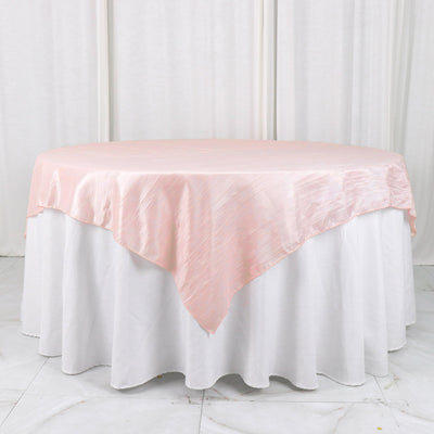 Pink satin tablecloth draped over a round table.