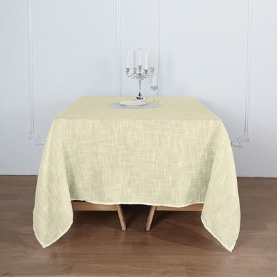 Beige textured tablecloth draped over a wooden table with a candelabra centerpiece.