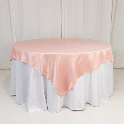 Round table with a pink satin tablecloth and white skirt