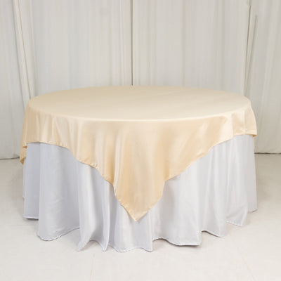 Round table with beige satin tablecloth and white skirt