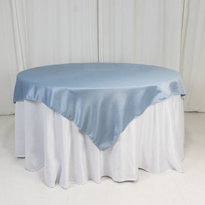 Round table with a light blue satin tablecloth and white skirt.