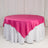 Round table with a pink satin tablecloth and white skirt.