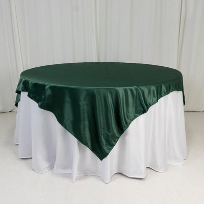 Green satin tablecloth draped over a round table