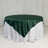 Green satin tablecloth draped over a round table